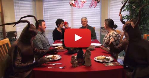 A family Thanksgiving dinner includes two people in cockroach costumes